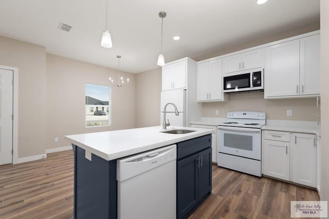 kitchen featuring sink, white cabinetry, decorative light fixtures, an island with sink, and white appliances