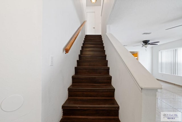 staircase featuring ceiling fan