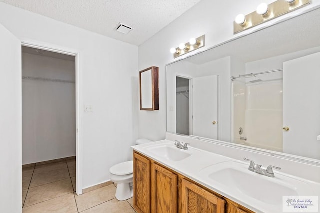 full bathroom featuring toilet, a textured ceiling, shower / bathtub combination, vanity, and tile patterned flooring