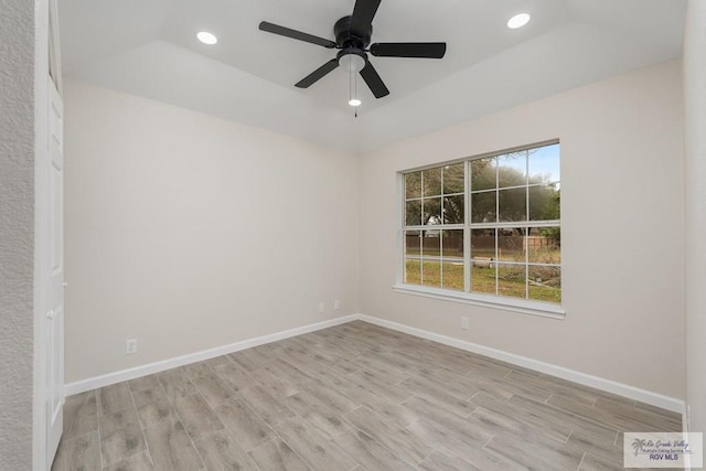 spare room featuring light hardwood / wood-style floors, a raised ceiling, and ceiling fan