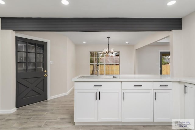 kitchen with hanging light fixtures, white cabinetry, plenty of natural light, and an inviting chandelier