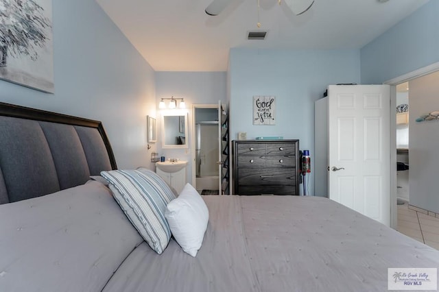 tiled bedroom featuring ceiling fan and connected bathroom