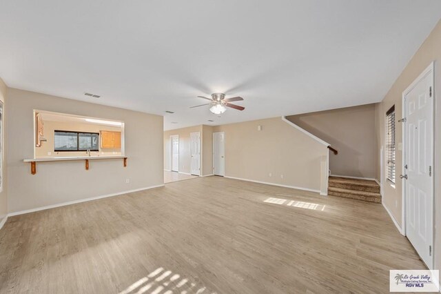 unfurnished living room featuring ceiling fan and light wood-type flooring