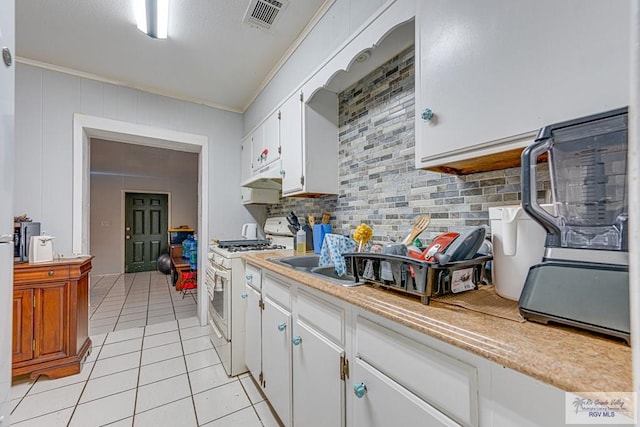 24 Ivy Ln, Brownsville, TX 78521 - kitchen featuring gas range gas stove, light countertops, light tile patterned floors, ornamental molding, and tasteful backsplash