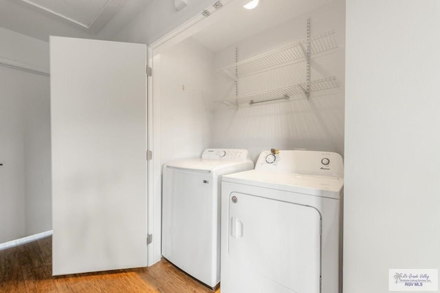 washroom featuring washer and clothes dryer and light hardwood / wood-style floors