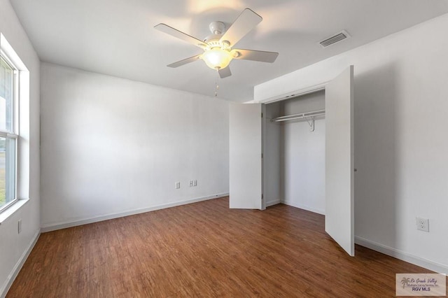 unfurnished bedroom featuring multiple windows and wood-type flooring