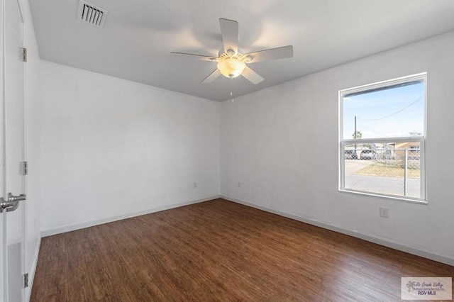 empty room featuring ceiling fan and dark hardwood / wood-style floors