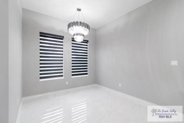 empty room featuring carpet flooring and a chandelier