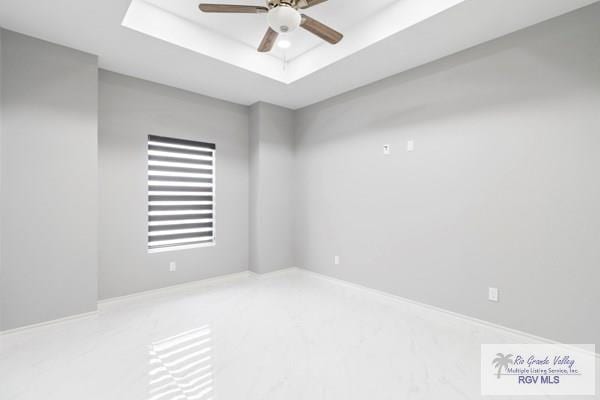 spare room with a raised ceiling and ceiling fan