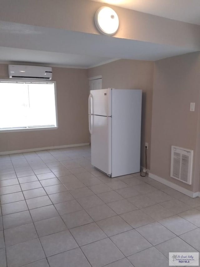 5824 Southmost Rd, Brownsville, TX 78521 - kitchen featuring light tile patterned floors, a wall unit AC, visible vents, and freestanding refrigerator