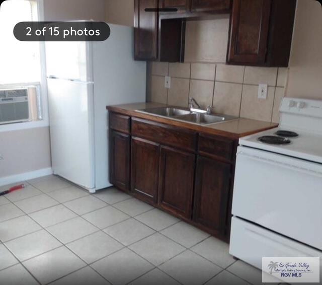 kitchen featuring dark brown cabinetry, sink, decorative backsplash, and white range with electric cooktop