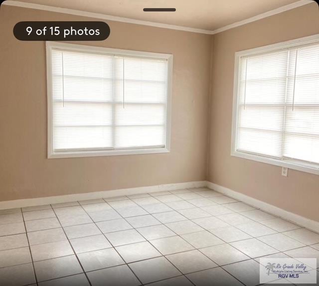 empty room with ornamental molding and light tile patterned floors