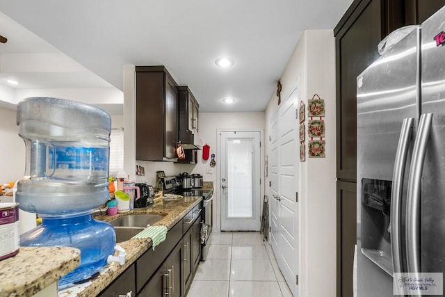 kitchen with light tile patterned floors, light stone countertops, stainless steel appliances, dark brown cabinets, and recessed lighting