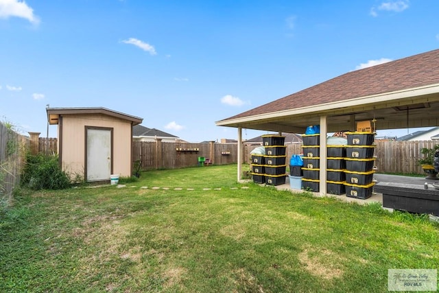 view of yard with a storage shed, a fenced backyard, and an outdoor structure