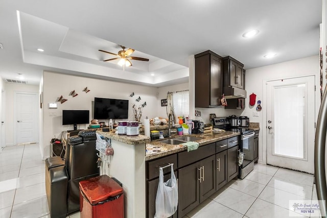 kitchen with light tile patterned floors, stone countertops, electric range, a sink, and a raised ceiling