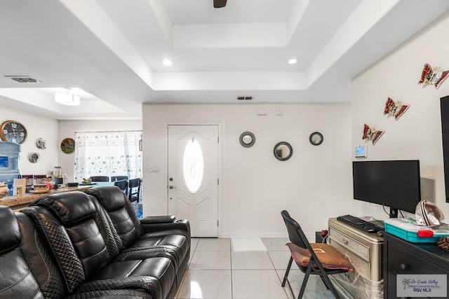 living room featuring light tile patterned floors, a raised ceiling, visible vents, and recessed lighting