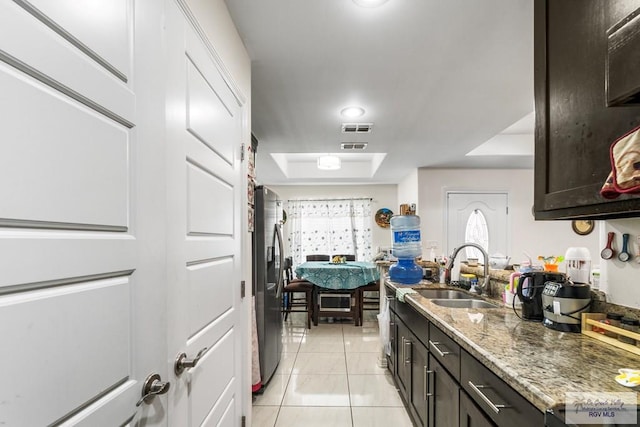 kitchen with light tile patterned flooring, a sink, visible vents, stainless steel fridge with ice dispenser, and a tray ceiling