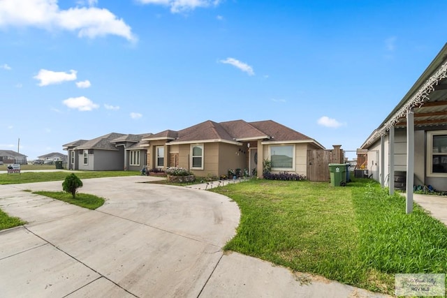 view of front facade with a front yard, driveway, and stucco siding