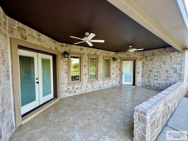 27281 Palm Blvd, Harlingen, TX 78552 - doorway to property featuring french doors, stone siding, a ceiling fan, and a patio area