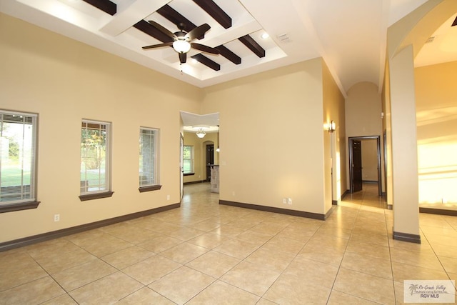 27281 Palm Blvd, Harlingen, TX 78552 - empty room with arched walkways, plenty of natural light, light tile patterned floors, coffered ceiling, and beamed ceiling