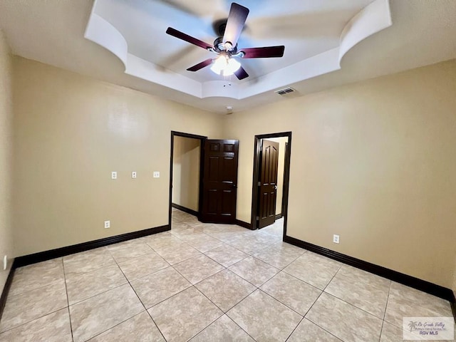 27281 Palm Blvd, Harlingen, TX 78552 - spare room featuring a tray ceiling, a ceiling fan, and light tile patterned flooring