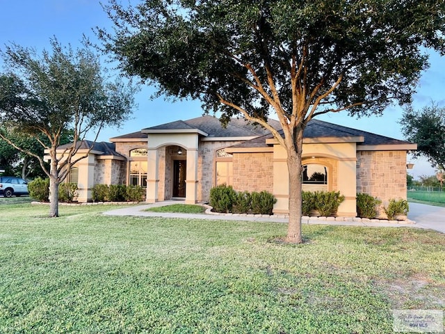 27281 Palm Blvd, Harlingen, TX 78552 - view of front of house with a front yard, stone siding, and stucco siding
