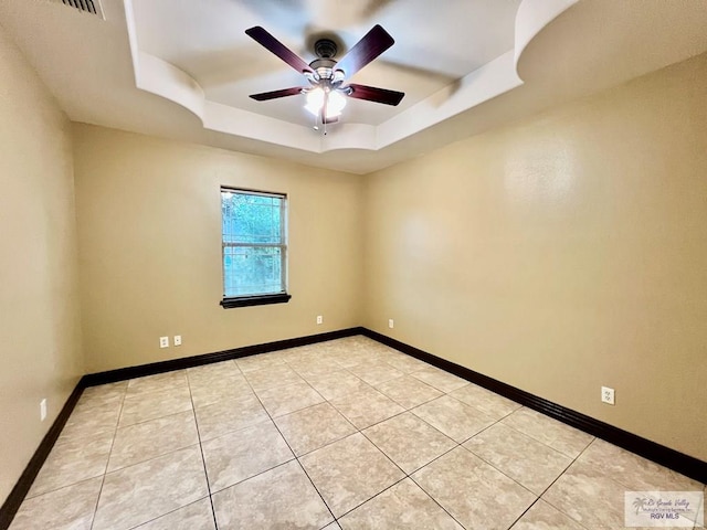 27281 Palm Blvd, Harlingen, TX 78552 - spare room featuring a raised ceiling, a ceiling fan, and light tile patterned floors