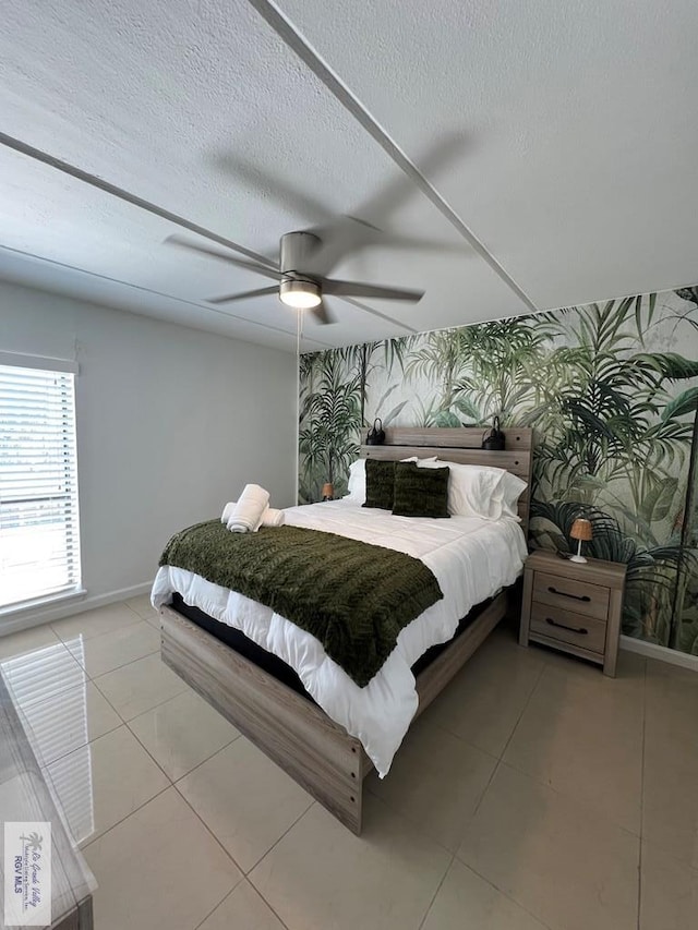 109 W Tarpon St Unit 301, South Padre Island, TX 78597 - bedroom featuring wallpapered walls, baseboards, an accent wall, light tile patterned floors, and a ceiling fan