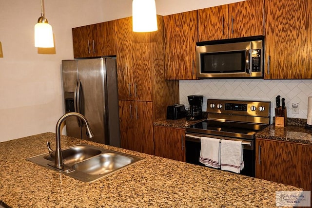 kitchen featuring stainless steel appliances, sink, decorative light fixtures, and decorative backsplash