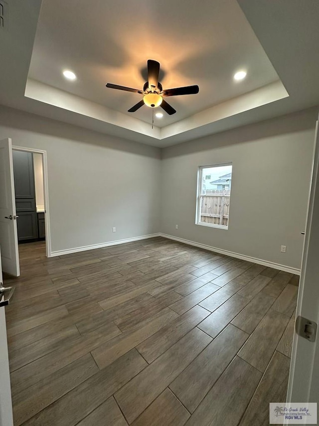 2299 Athens St, Brownsville, TX 78520 - empty room featuring a tray ceiling, ceiling fan, dark wood-style floors, and recessed lighting