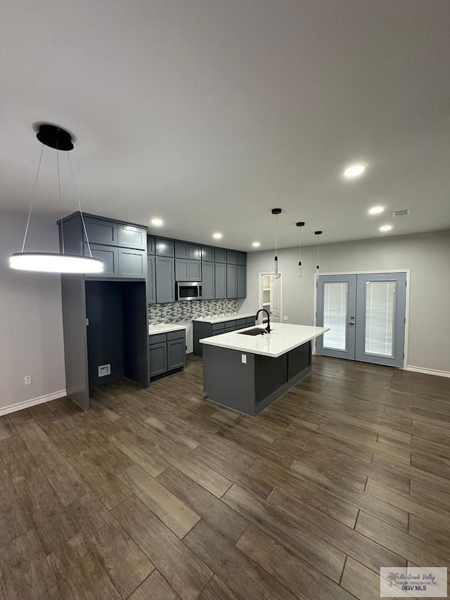 2299 Athens St, Brownsville, TX 78520 - kitchen with dark wood finished floors, stainless steel microwave, light countertops, french doors, and recessed lighting