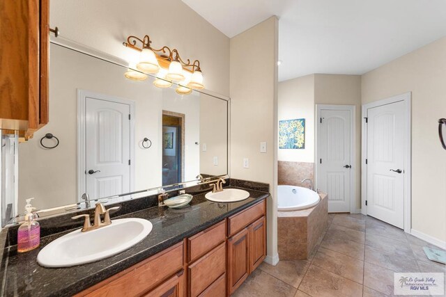 bathroom with vanity, tile patterned floors, and tiled tub