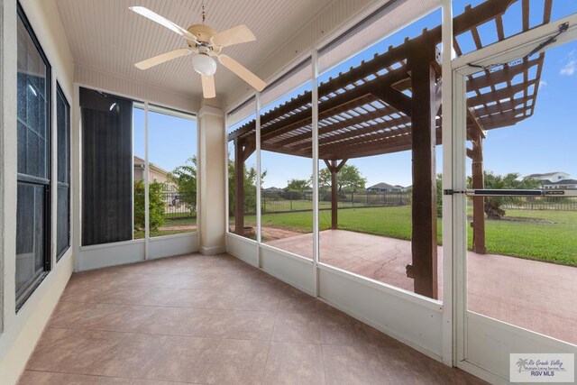 unfurnished sunroom with ceiling fan