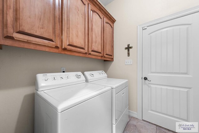 laundry room featuring cabinets and washer and clothes dryer