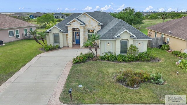 view of front of house with central AC unit and a front lawn