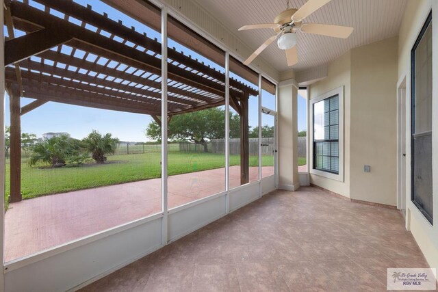 unfurnished sunroom featuring ceiling fan