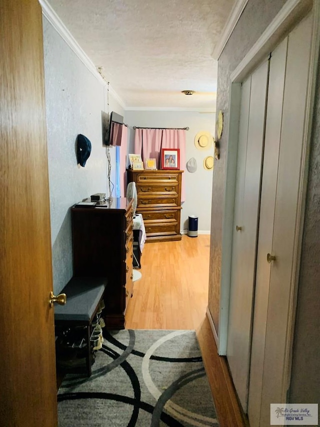 hall with hardwood / wood-style floors and ornamental molding