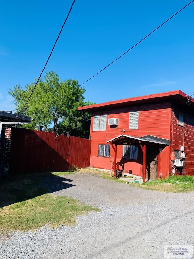 view of front of home with a wall mounted air conditioner