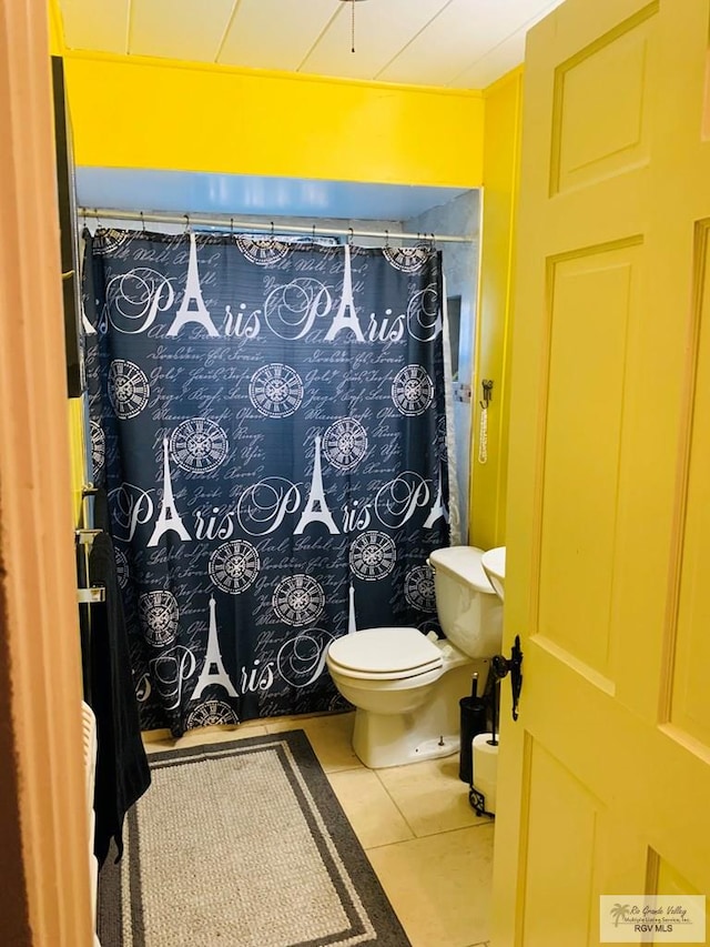 bathroom with toilet, a shower with curtain, and tile patterned floors