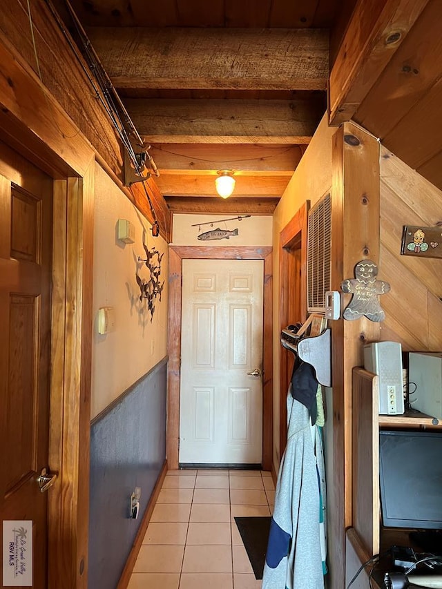 doorway to outside with beam ceiling and light tile patterned floors