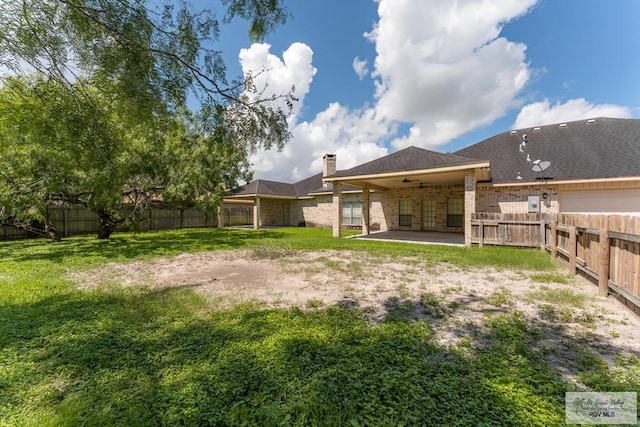 rear view of house with a patio area, ceiling fan, and a yard