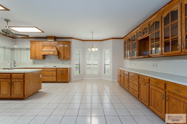 kitchen with custom range hood, ceiling fan with notable chandelier, crown molding, decorative light fixtures, and light tile patterned flooring