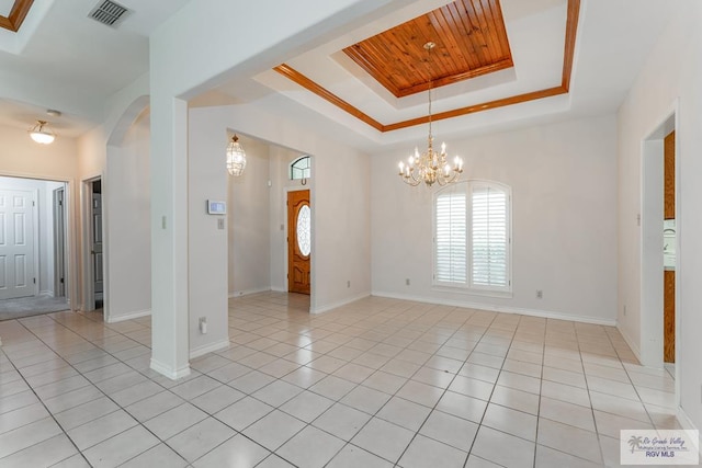 unfurnished room featuring wood ceiling, a raised ceiling, crown molding, an inviting chandelier, and light tile patterned flooring