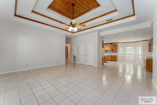 unfurnished living room with ceiling fan with notable chandelier, light tile patterned flooring, and a raised ceiling