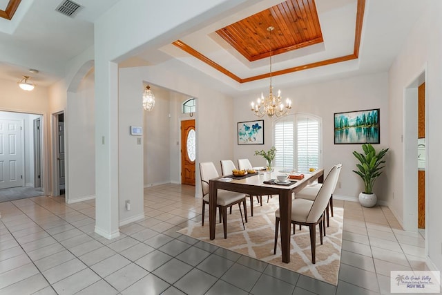 tiled dining space featuring a chandelier, a raised ceiling, crown molding, and wood ceiling