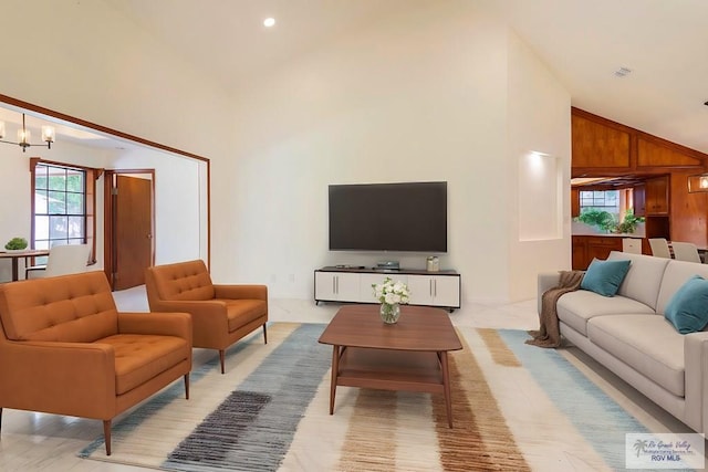 living room featuring a chandelier, light hardwood / wood-style floors, high vaulted ceiling, and wooden walls