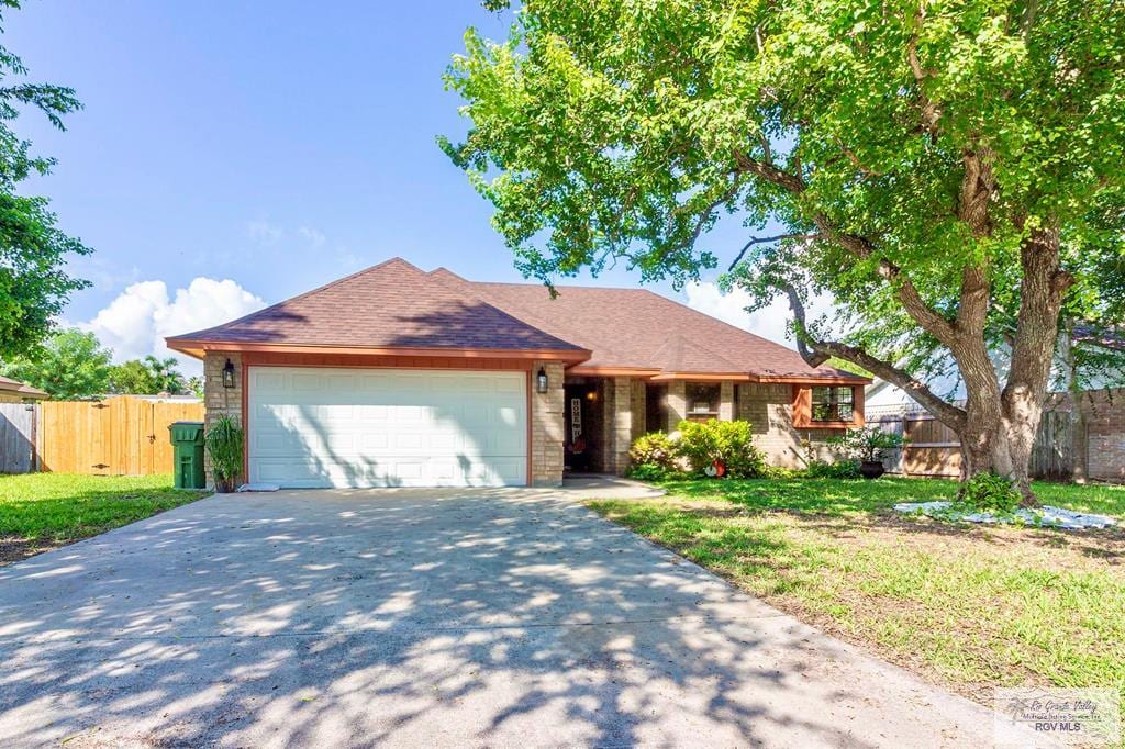 ranch-style house featuring a front yard and a garage