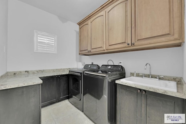 laundry room featuring cabinets, washing machine and dryer, sink, and light tile patterned floors