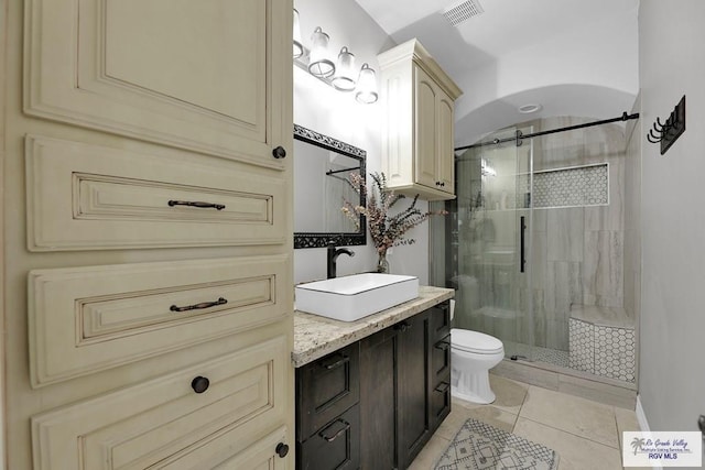 bathroom featuring an enclosed shower, vanity, tile patterned floors, and toilet