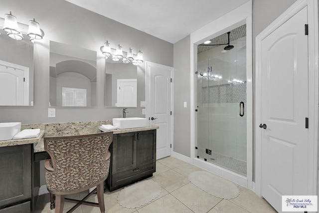 bathroom featuring tile patterned flooring, vanity, and walk in shower